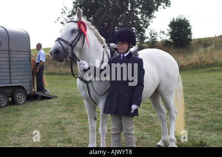 Eriskay Pony e pilota in occasione di una mostra con un Red Rosette Foto Stock