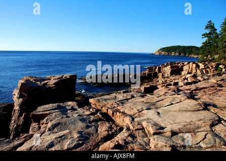 Questa fotografia mostra un caldo sporgenza di roccia lungo una linea costiera. A distanza di una suola penisola indugia nell'alloggiamento. Foto Stock