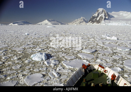 L'Antartide, expedition cruise ship Ms. mondo scopritore passando attraverso il ghiaccio con i turisti in prua. Foto Stock