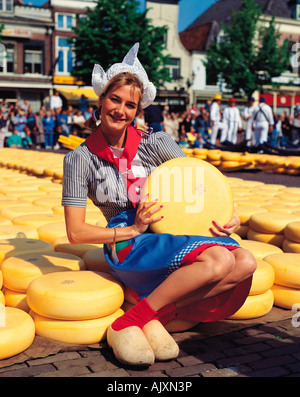 Paesi Bassi. Amsterdam, Alkmaar, mercato del formaggio, donna in abiti tradizionali con formaggi, Foto Stock