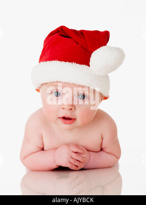 Formato ritratto foto di un simpatico baby in Santa Babbo Natale Hat in perspex bianco contro sfondo bianco Foto Stock