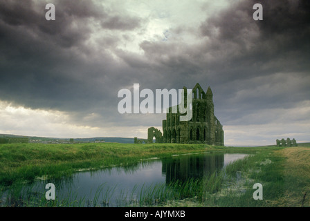 Whitby Abbey riflessa nello stagno e stagliano contro un cielo tempestoso Foto Stock