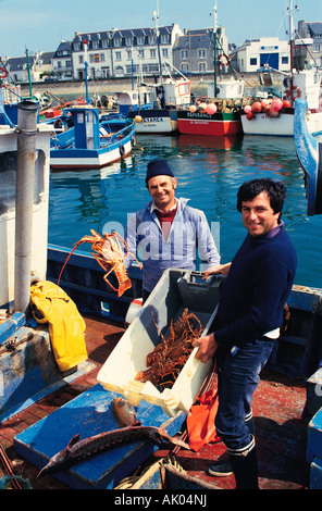 Europa. Francia. Bretagna. Le Guilvinec. Pescatori di aragosta nel porto che mostrano le loro catture. Foto Stock