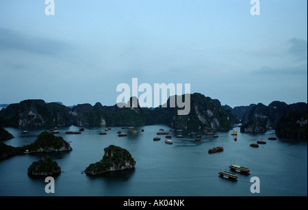 Vista di giunche e altre imbarcazioni sulla parte superiore di una delle formazioni carsiche nella baia di Halong, Vietnam Foto Stock