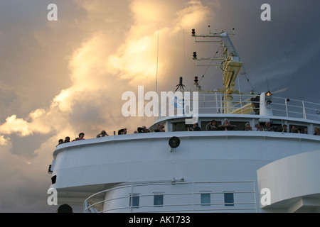 La nave di crociera passeggeri su un ponte di Navi e guardare il tramonto Foto Stock