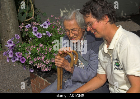 Anziana madre e figlia adulta parlando in giardino Foto Stock