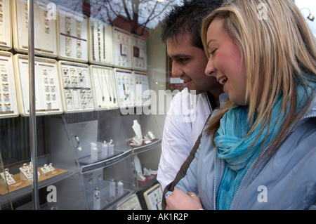 giovane coppia di razza mista che guarda in gioielleria vetrina ridendo felice yoog persone adulte Foto Stock