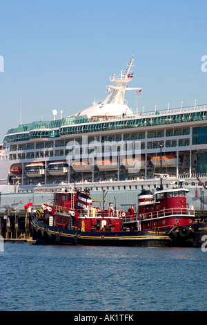 Portland Harbour nave da crociera al dock protetti daun flotta di Harbour fireboats in primo piano Foto Stock