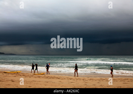 Persone e nuvole temporalesche della costa a Manly Beach Sydney Australia Foto Stock