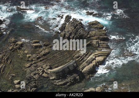 Mare di onde che si infrangono contro le rocce Foto Stock