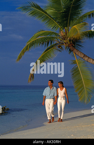Maldive. Coppia giovane camminando mano nella mano sulla spiaggia tropicale. Foto Stock