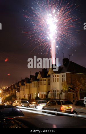 Fuochi d'artificio esplosione di colori sulla fila di case a Londra di Notte Foto Stock