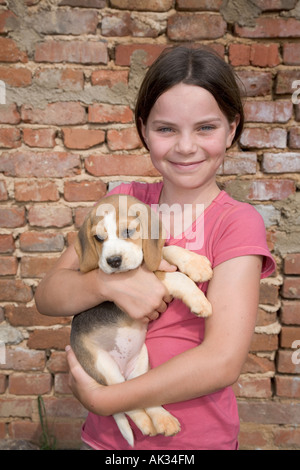 10 anno vecchia ragazza detiene il beagle cucciolo di cane Foto Stock