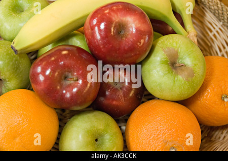 Una coppa di frutta con arance mele e banane in esso Foto Stock