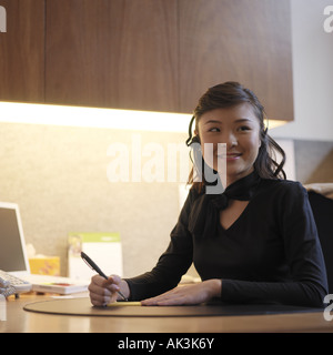 Giovane donna executive prendendo i messaggi verso il basso Foto Stock