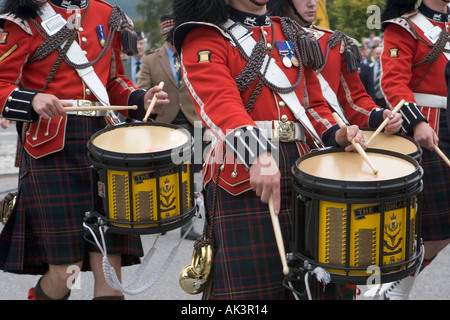 Scottish Highland Games - suonatori di tamburi rivestiti di rosso, musicisti e artisti in Pipe band che suonano a Braemar, Cairngorms National Parks, Scozia, Regno Unito Foto Stock