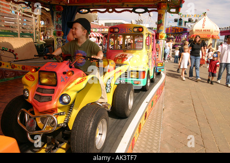 Un giovane bambino seduto in un quad bike su un luna park ride. Bridlington REGNO UNITO Foto Stock