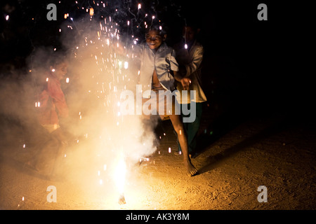 Indian bambini che giocano attorno a un fuoco d'artificio Foto Stock