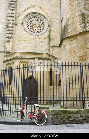 Una bicicletta è incatenato ad una ringhiera di ferro al di fuori di una chiesa a San Sebastian Vecchia, Spagna. Foto Stock