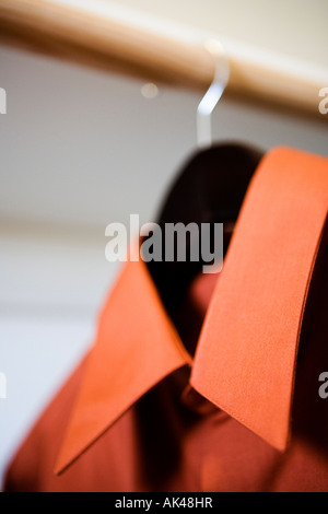 A collare rosso Dress shirt appeso in armadio Foto Stock