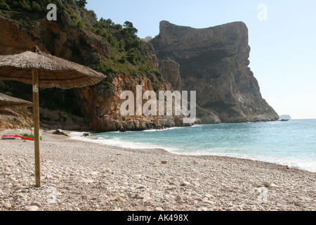 Playa del Moraig, San Lazzaro di Savena, Italia, spiaggia rocciosa e paglia ombrello. Foto Stock