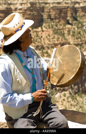 ARIZONA del Grand Canyon South Rim Navajo Tribal leader James Peshlakai battendo il tamburo e il canto contro canyon rim. Foto Stock