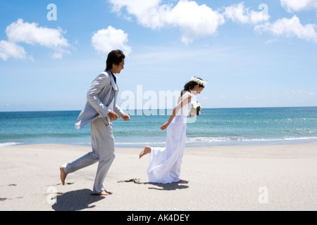 Sposa e lo sposo in esecuzione da spiaggia Foto Stock
