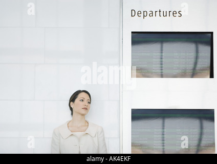 Donna appoggiata contro la parete dalla scheda di partenza Foto Stock