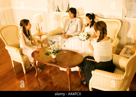 Sposa e lo sposo rilassante con gli amici, in alto angolo di visione Foto Stock