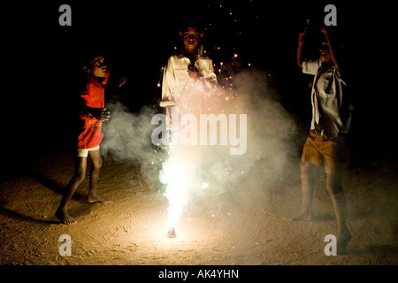 Indian bambini che giocano attorno a un fuoco d'artificio Foto Stock