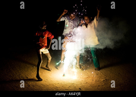 Indian bambini che giocano attorno a un fuoco d'artificio Foto Stock