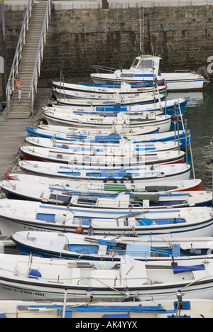 Barche da pesca allineate lungo un molo nel porto di Getaria in Spagna la costa basca. Foto Stock