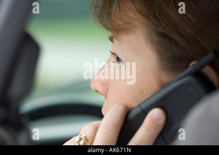 Giovane donna parlando al cellulare in auto Foto Stock
