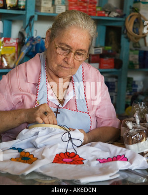 Donna facendo ricami in negozio Foto Stock