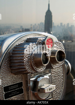A gettone binocolo impostata su uno sfondo dell'Empire State Building, visto dalla parte superiore della roccia" di New York Foto Stock