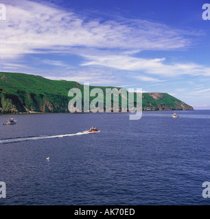 Costa est vista e fine di Lundy Island off N Devon Coast come piccola barca fa scia bianca in acqua Inghilterra Foto Stock