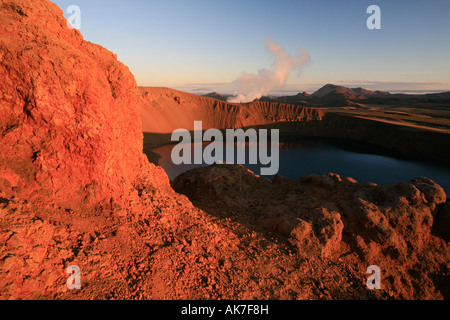 Il cratere vulcanico viti con il lago nella zona di Krafla nella luce rossa del tramonto, maar Viti, paesaggio islandese Foto Stock