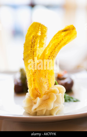 Close up di piatto con nitide banana chips su piastra Foto Stock