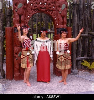 Tre donne Maori in piedi dal Gateway scolpito a Whakarewarewa Rotorua Isola del nord della Nuova Zelanda Foto Stock