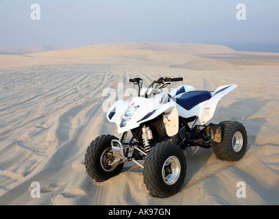 Un quadbike nel mezzo del deserto Qatar Suzuki logo di società non sono stati rimossi Foto Stock