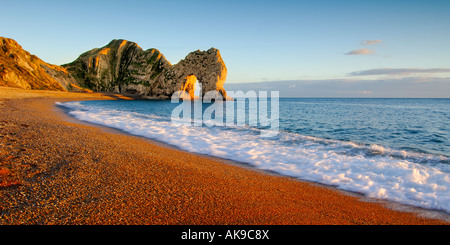 Luce calda al tramonto su La costa del Dorset guardando ad est verso la porta di Durdle con un cielo blu chiaro in panoramica Foto Stock