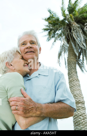 Coppia senior sorridente e nuzzling, Palm tree in background, basso angolo di visione Foto Stock