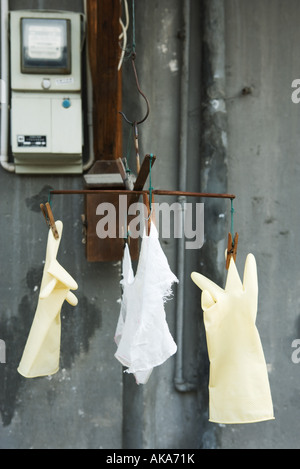 Guanti di plastica e rag appesi ad asciugare Foto Stock