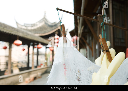 Guanti di plastica e rag appesi ad asciugare le lanterne cinesi appeso in background Foto Stock