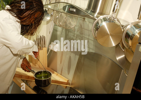 Nero donna una cottura in cucina Foto Stock