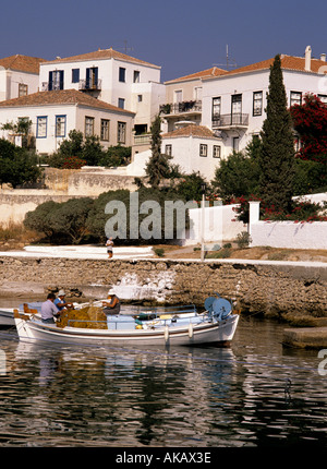 I pescatori seduti in barca locale di riparazione di reti da pesca Parga Grecia mediterraneo Foto Stock