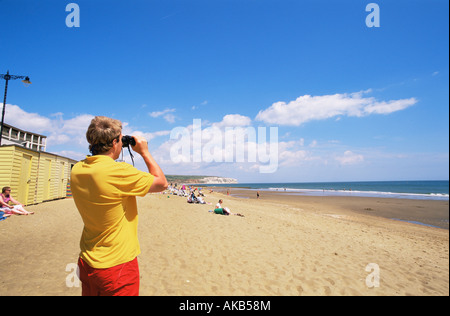 Inghilterra, Hampshire, Isle of Wight, Sandown, bagnino guardando attraverso il binocolo sulla spiaggia di Sandown Foto Stock