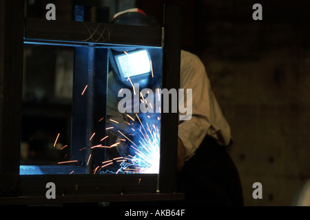 Lavoratore in una macinazione di Chicago società utilizza il cannello da taglio su acciaio Foto Stock