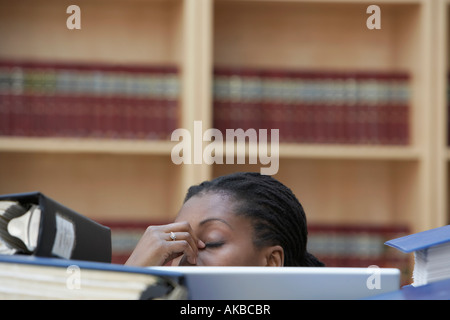 Lavoratore di ufficio seduti dietro pile di documenti in ufficio, sezione elevata Foto Stock