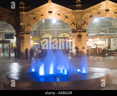 Una fontana e funzione acqua illuminata da luce blu durante la notte in un covone Square, al di fuori di Sheffield stazione ferroviaria, South Yorkshire Regno Unito Foto Stock